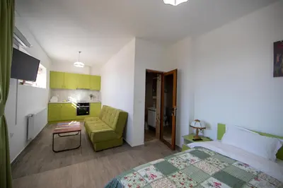 a bedroom with a bed and a couch and a table at Къща за гости детелина - лина in Sapareva Banya