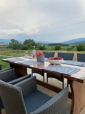 a wooden table with chairs and a bowl of flowers on it at HomeRevolution in Marikostinovo