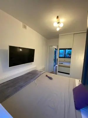 a bedroom with a large bed with a flat screen tv at HomeRevolution in Marikostinovo
