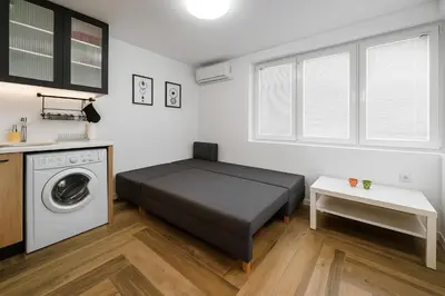 a bedroom with a bed and a washing machine at North Panoramic Apartment in the art district of Kapana in Plovdiv