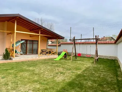 a yard with a playground in front of a house at Къщи за гости “Планински Рай” Mountain Paradise in Resilovo