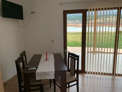 a dining room with a table and chairs and a large window at Къщи за гости “Планински Рай” Mountain Paradise in Resilovo