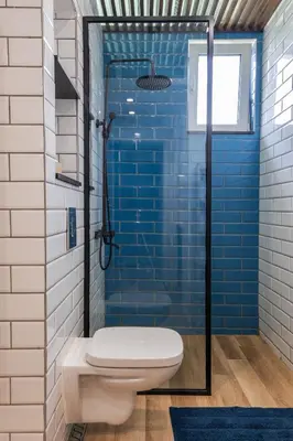 a bathroom with a toilet and a shower with blue tiles at 2BD Flamingo Flat with Balcony in Sofia Center by Flat Mаnager in Sofia