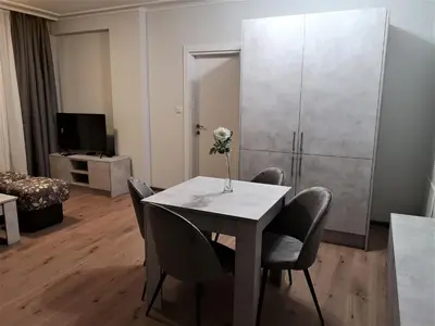 a room with a table with chairs and a refrigerator at Sofia hotel apartments in Sofia