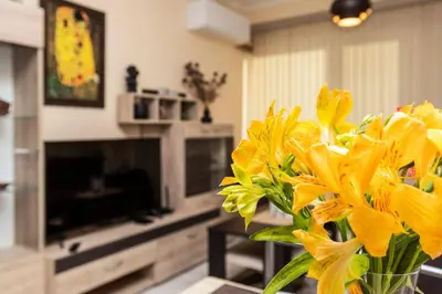 a vase filled with yellow flowers in a living room at Cozy new Apartment 'Casa Vacanza ' ✵ TOP CENTER ✵ in Plovdiv