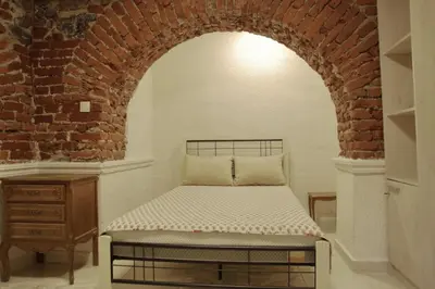 a bed in a room with a brick wall at Top Center Detached Apartment Studio in Sofia