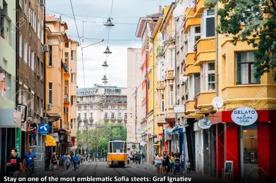 a tram on a city street with buildings at Top Center Detached Apartment Studio in Sofia