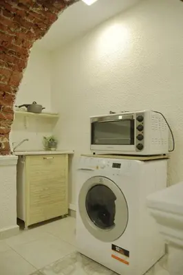 a microwave on top of a washing machine in a kitchen at Top Center Detached Apartment Studio in Sofia