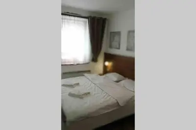 a bedroom with a white bed with a window at Belvedere Holiday Club VIP Apartment H 82 in Bansko