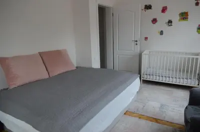a bedroom with a bed and a crib at Brand New Apartment in Sofia