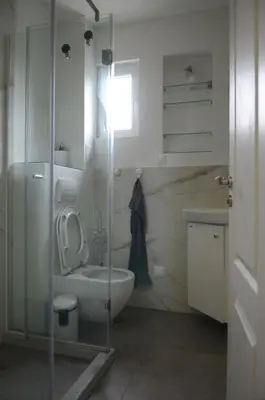 a bathroom with a toilet and a glass shower at Brand New Apartment in Sofia