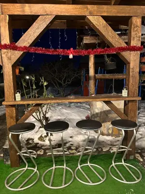 a table and two stools under a table at Къща за гости Даутев Връх in Bansko
