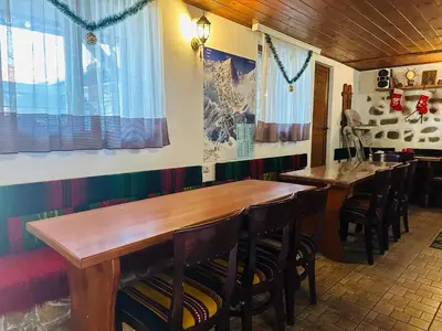 a dining room with wooden tables and chairs at Къща за гости Даутев Връх in Bansko