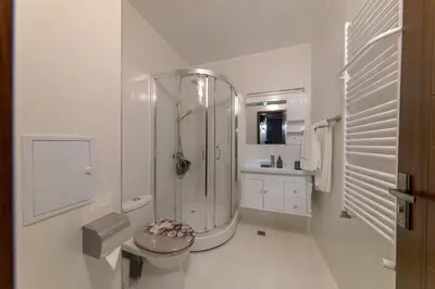 a white bathroom with a shower and a toilet at Luxury 2-bedroom apartment by Studenets Center by Flat Mаnager in Pamporovo
