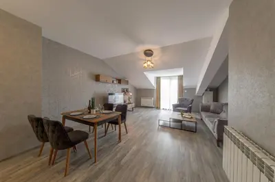 a living room with a table and chairs and a couch at Luxury 2-bedroom apartment by Studenets Center by Flat Mаnager in Pamporovo