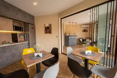 a dining room with two tables and yellow chairs at Family Hotel Konstantinovi in Kyustendil
