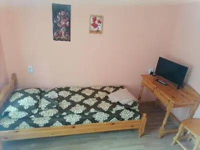 a bedroom with a bed and a wooden desk at Guest House Shipkovo Hills in Shipkovo