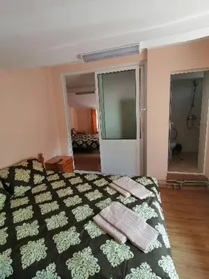 a bedroom with a bed with two towels on it at Guest House Shipkovo Hills in Shipkovo