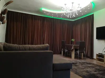 a living room with a table and a chandelier at Вила Мая 2 in Krayni Dol