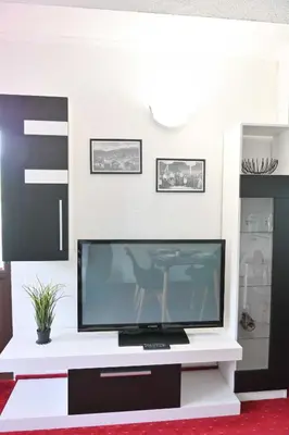 a living room with a tv on a white entertainment center at Discovery Apartment Bansko in Bansko