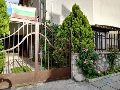 a gate to a house with a flag on it at Discovery Apartment Bansko in Bansko