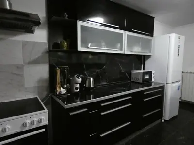 a kitchen with black counters and a white refrigerator at Grande - Velingrad in Velingrad