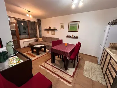 a living room with a table and a couch at Апартамент Планинско Гнездо - Mountain Nest in Stoykite