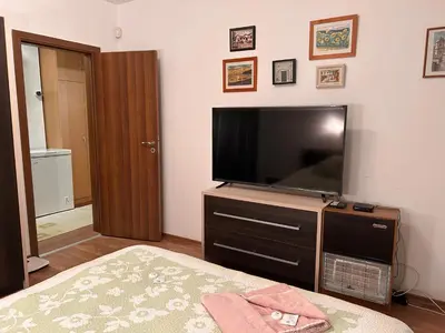 a bedroom with a flat screen tv and a bed at Апартамент Планинско Гнездо - Mountain Nest in Stoykite