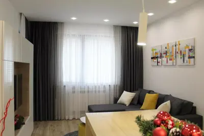 a living room with a couch and a table at Borovets Gardens Luxury apartment E11 in Borovets