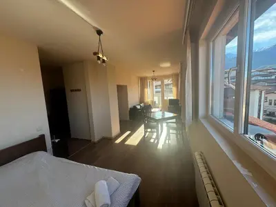 a bedroom with a bed and a table and a window at Bansko Royal Towers - Studio 153 in Bansko