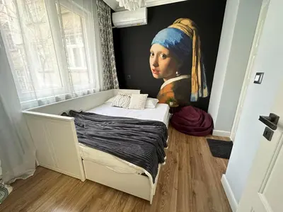 a bedroom with a painting of a woman with a head at Top Center 2 Aptartments - Gurko Str in Sofia