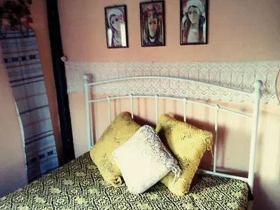 a bedroom with a white bed with two pillows on it at Старата къща / село Тъжа in Tŭzha