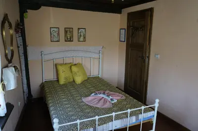 a small bedroom with a bed with a green bedspread at Старата къща / село Тъжа in Tŭzha