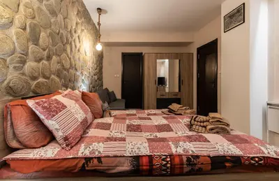 a bedroom with a bed with a quilt on it at Ковачева-3 in Bansko