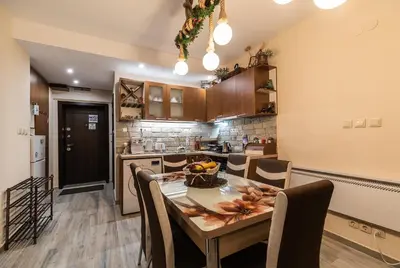 a kitchen with a table with a bowl of fruit on it at Ковачева-3 in Bansko