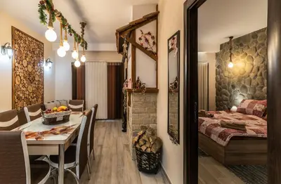 a room with a dining table and a bedroom at Ковачева-3 in Bansko