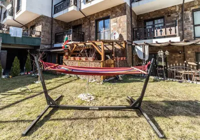 a hammock in a yard in front of a building at Ковачева-3 in Bansko