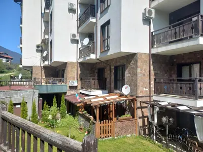 an apartment building with a wooden fence in front of it at Ковачева-3 in Bansko