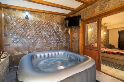 a bath tub in a room with a bedroom at Ковачева-3 in Bansko