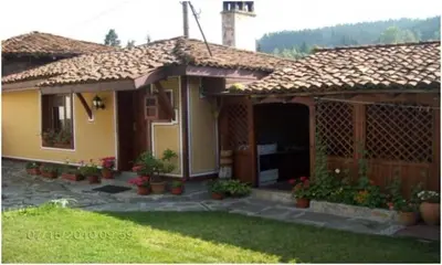 a small house with a porch and a yard at Янко Кехая in Koprivshtitsa