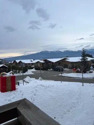 a snow covered yard with houses and a parking lot at Pirin Golf Hotel Private Studios - Sani, Bansko in Razlog