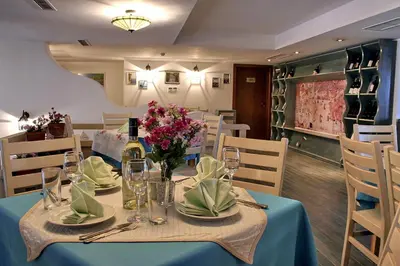 a dining room with a table with a bottle of wine at Pirin Golf Hotel Private Studios - Sani, Bansko in Razlog