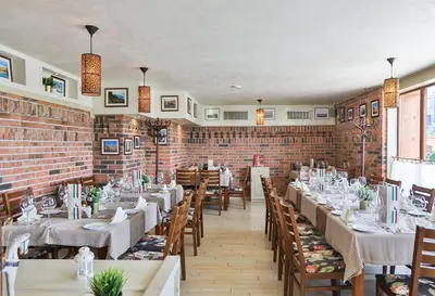 a restaurant with tables and chairs and a brick wall at Pirin Golf Hotel Private Studios - Sani, Bansko in Razlog