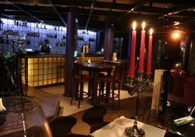 a restaurant with a bar with tables and red candles at Pirin Golf Hotel Private Studios - Sani, Bansko in Razlog