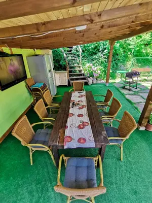 a wooden table and chairs under a roof at Вила Край реката in Botevgrad