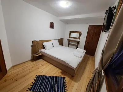 a small bedroom with a bed and a wooden floor at Вила 111 in Sapareva Banya