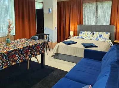 a bedroom with a bed and a table and a couch at Студио Цвят/ Studio Colour in Blagoevgrad