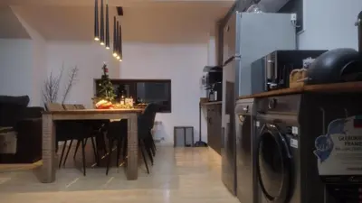 a living room with a table and a kitchen with a washing machine at Pearl XL in Pamporovo