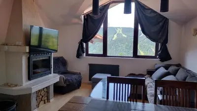 a living room with a couch and a tv at Pearl XL in Pamporovo