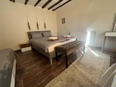 a bedroom with a bed and a bench in it at Къща Христини in Kalofer